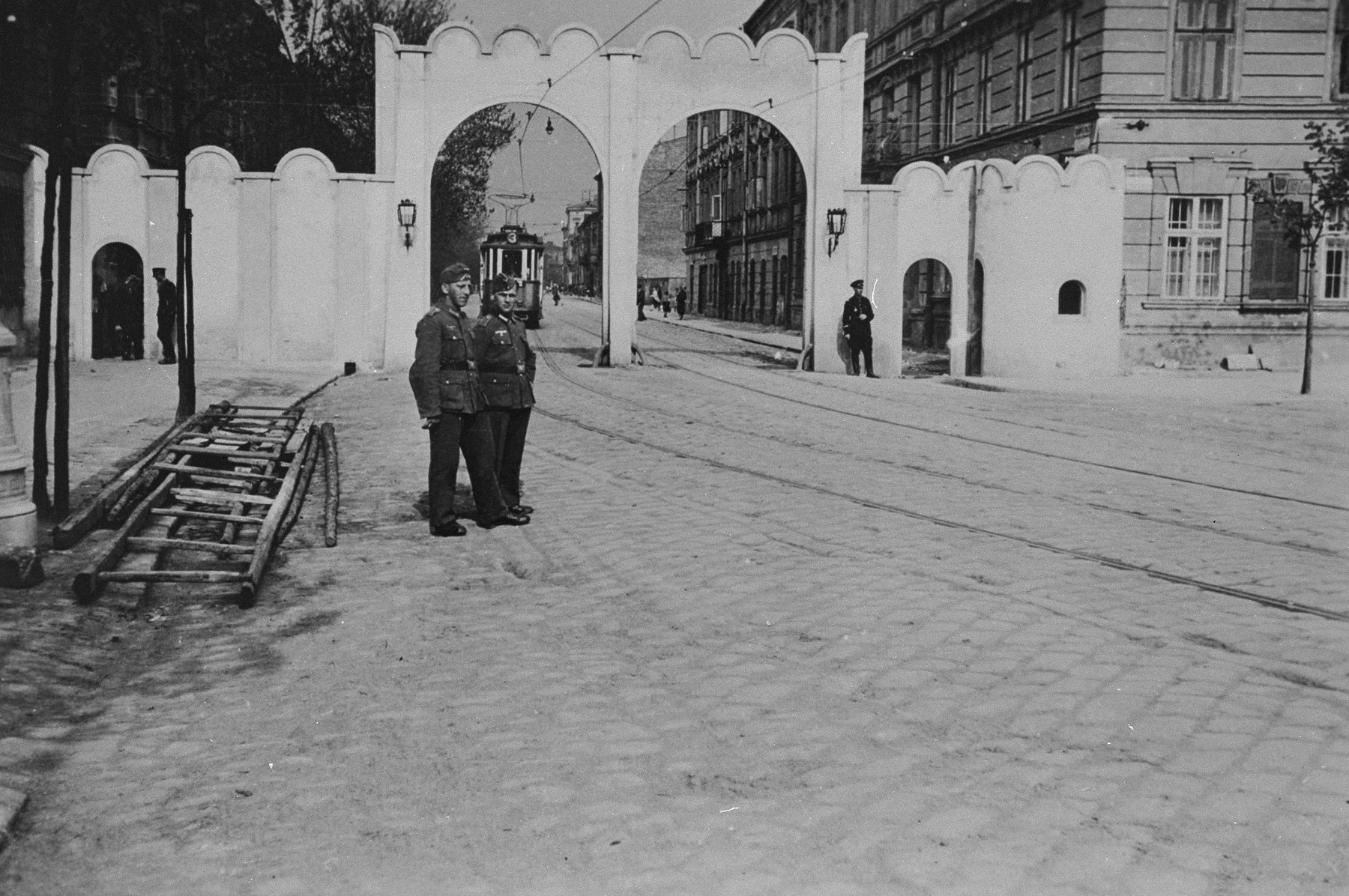 Two German soldiers pose near the gate at the entrance to the Krakow ghetto.