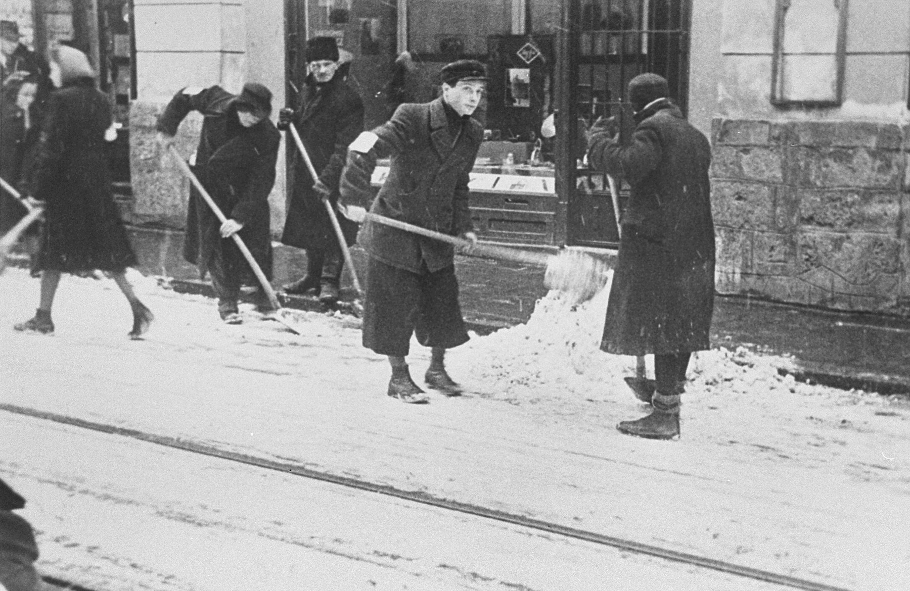 Jews wearing armbands are forced to shovel snow from the pavement in Krakow.