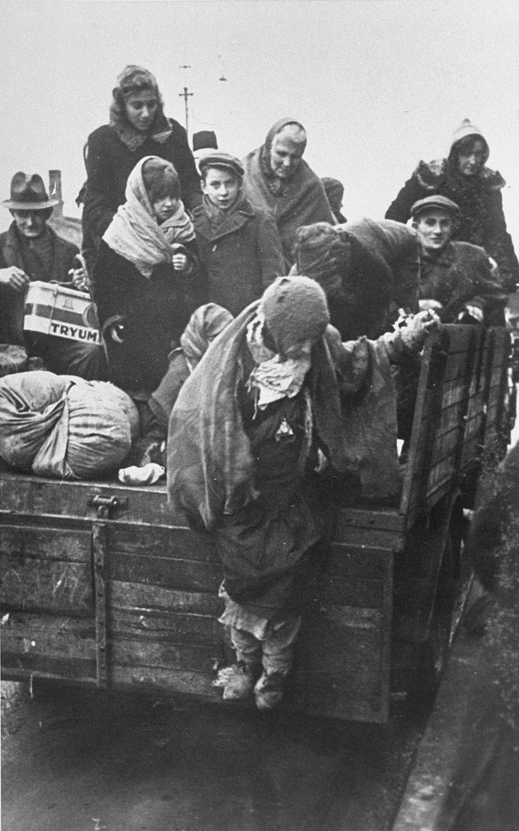 Jews from the Krakow ghetto, who have been rounded-up for deportation, are crowded onto the back of a truck.