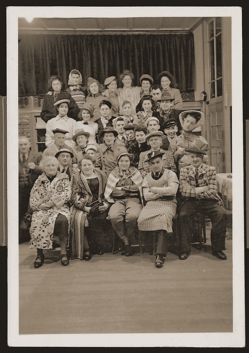 Group portrait of members of the Jewish community of Eibergen, who are in attendance at a New Year's Eve costume party at the Zion fabric store.
