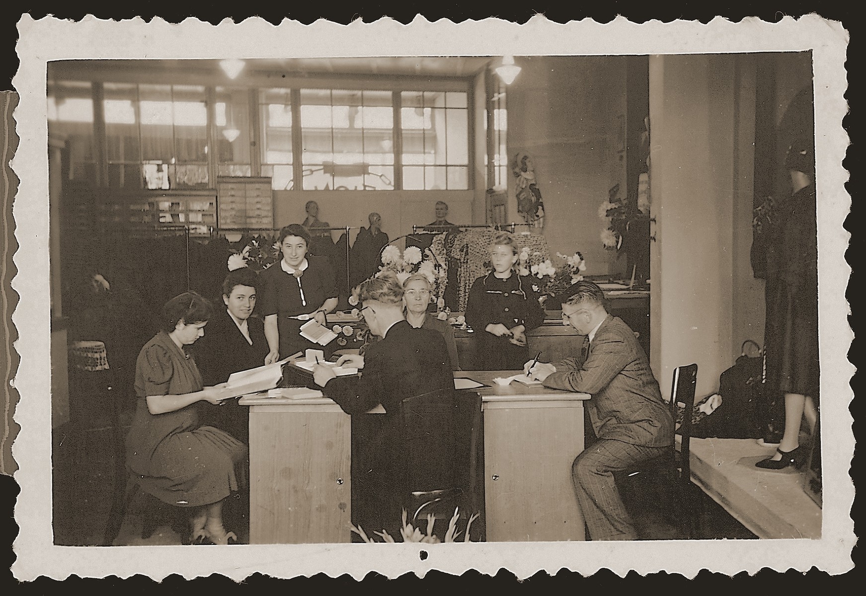 Employees of the Zion clothing and fabric store make preparations for the official re-opening of the business six months after the liberation.