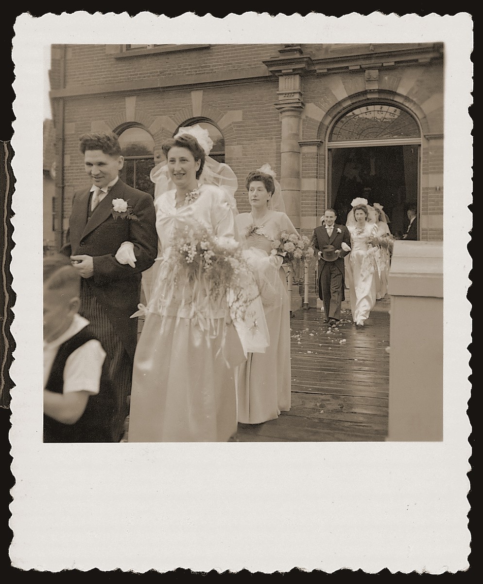 Two Jewish couples and their attendants file out of the city hall in Boekelo after a joint civil marriage ceremony.  They are now on their way to a local hotel, where the religious ceremony will take place. 

Pictured in front are Bep Meijer and Sallie Zion and behind, Mathilde Hartog and Richard Meijer.  Neither couple could afford the cost of a private ceremony.