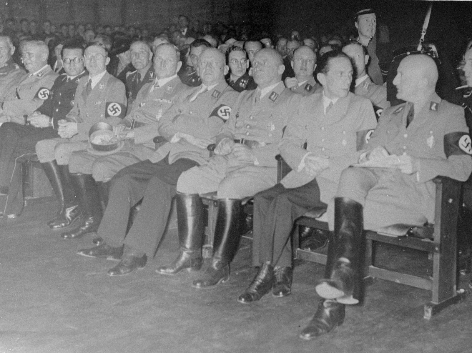 Julius Streicher, Joseph Goebbels and other Nazi officials attend the opening ceremony for "The Eternal Jew" in Munich.

The individuals in the front row (left to right) have been identified as General Werner von Blomberg (partial view), Ludwig Siebert, Phillip Bouhler, Karl Fiehler, Franz Xaver Ritter von Epp, Adolf Wagner, Julius Streicher, Josef Goebbels, and Otto Nippold. Pictured in the second row, between Goebbels and Streicher is  Deputy Gauleiter Georg Tesche.