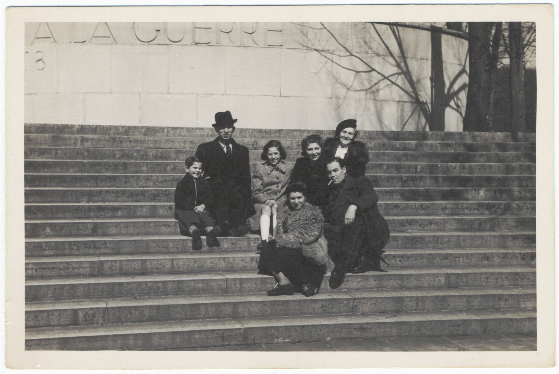 A Jewish family and their friends pose on the steps of a war memorial in Lyon where they are living semi-clandestinely under their own names.

Pictured in the back from left to right are Josey, Alexander, Renee, Luba and Yetta Fainas.  In front are two friends.