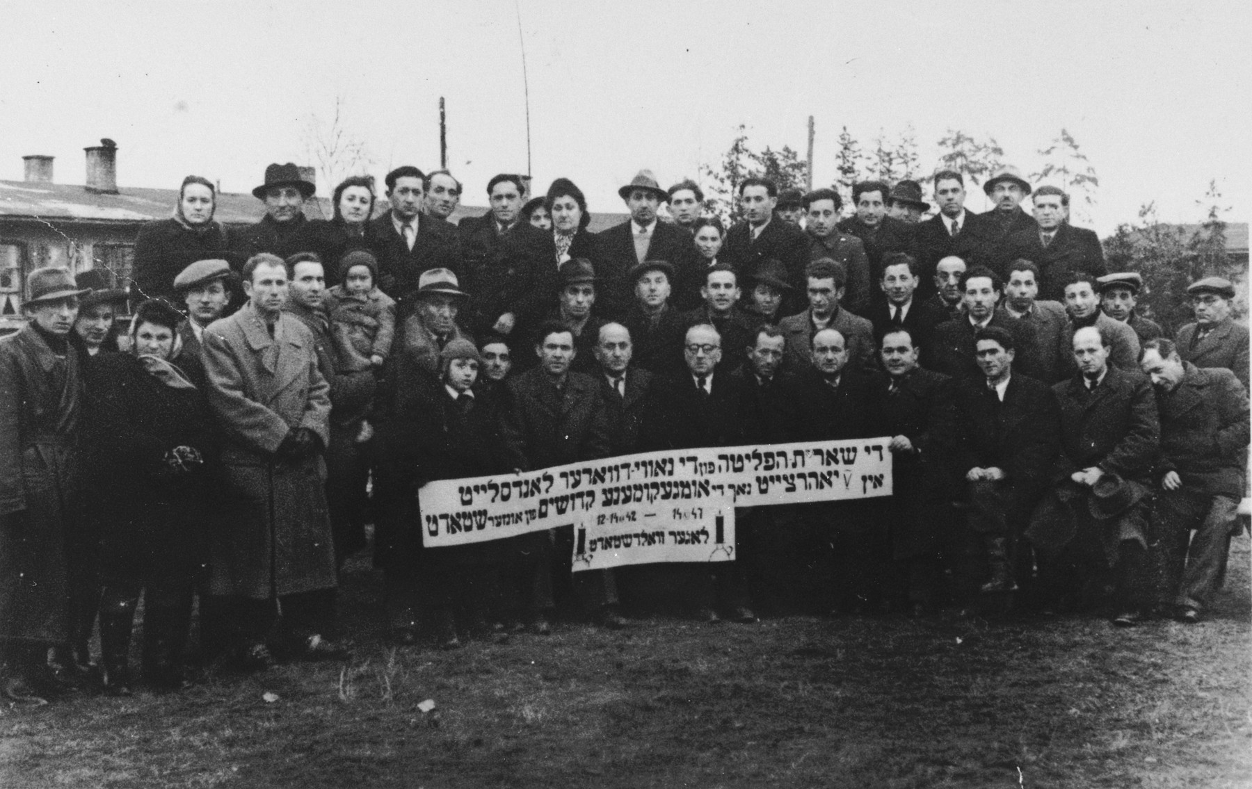 Group portrait of survivors at a commemoration of the destruction of the Jewish community of Nowy Dwor by the Nazis.  The commemoration took place at the Pocking displaced persons camp.

Pictured in the first row, fifth from the right is Iser Knecht.