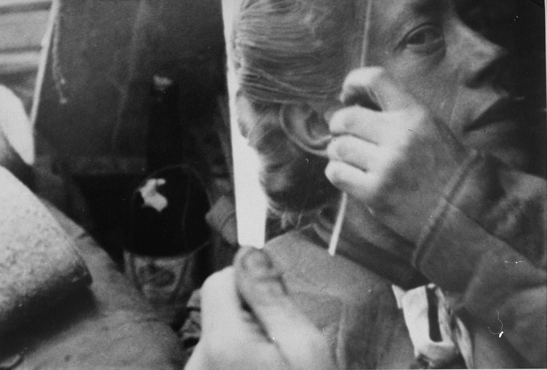 A Bergen-Belsen survivor brushes her hair.