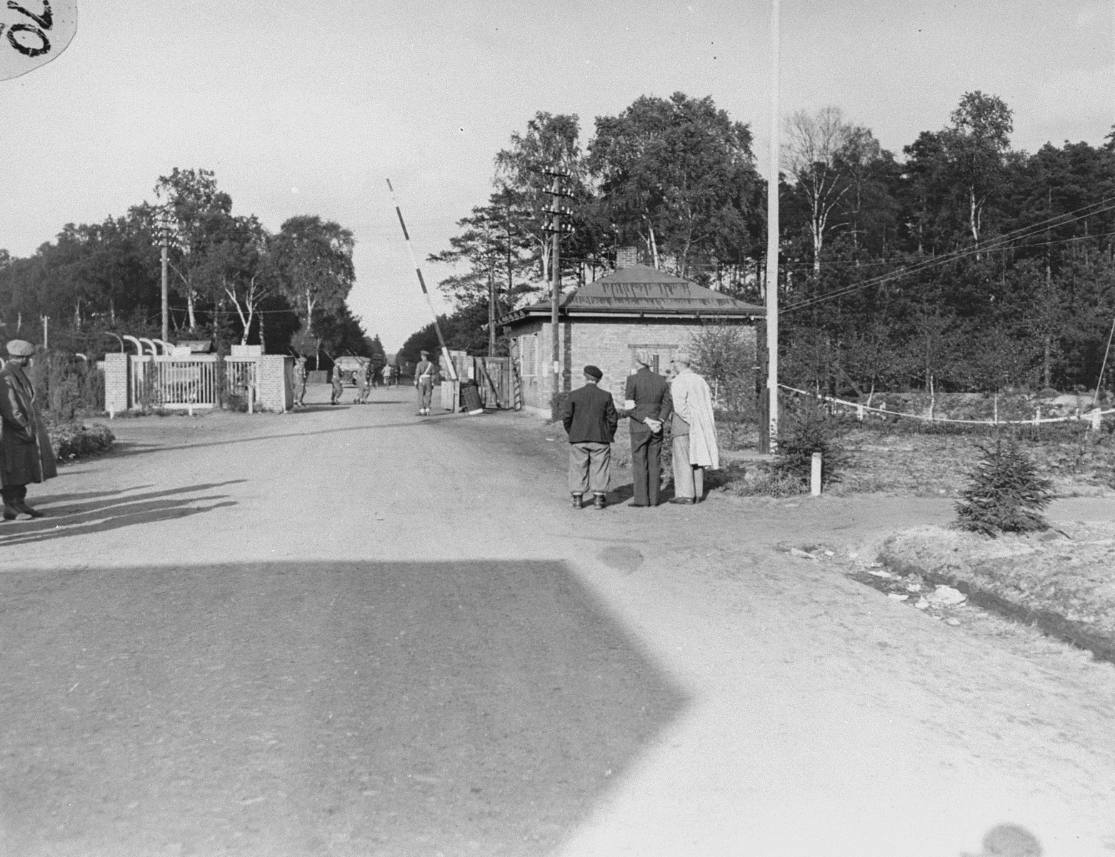 Survivors on the street in Bergen-Belsen facing the main gate to the camp.