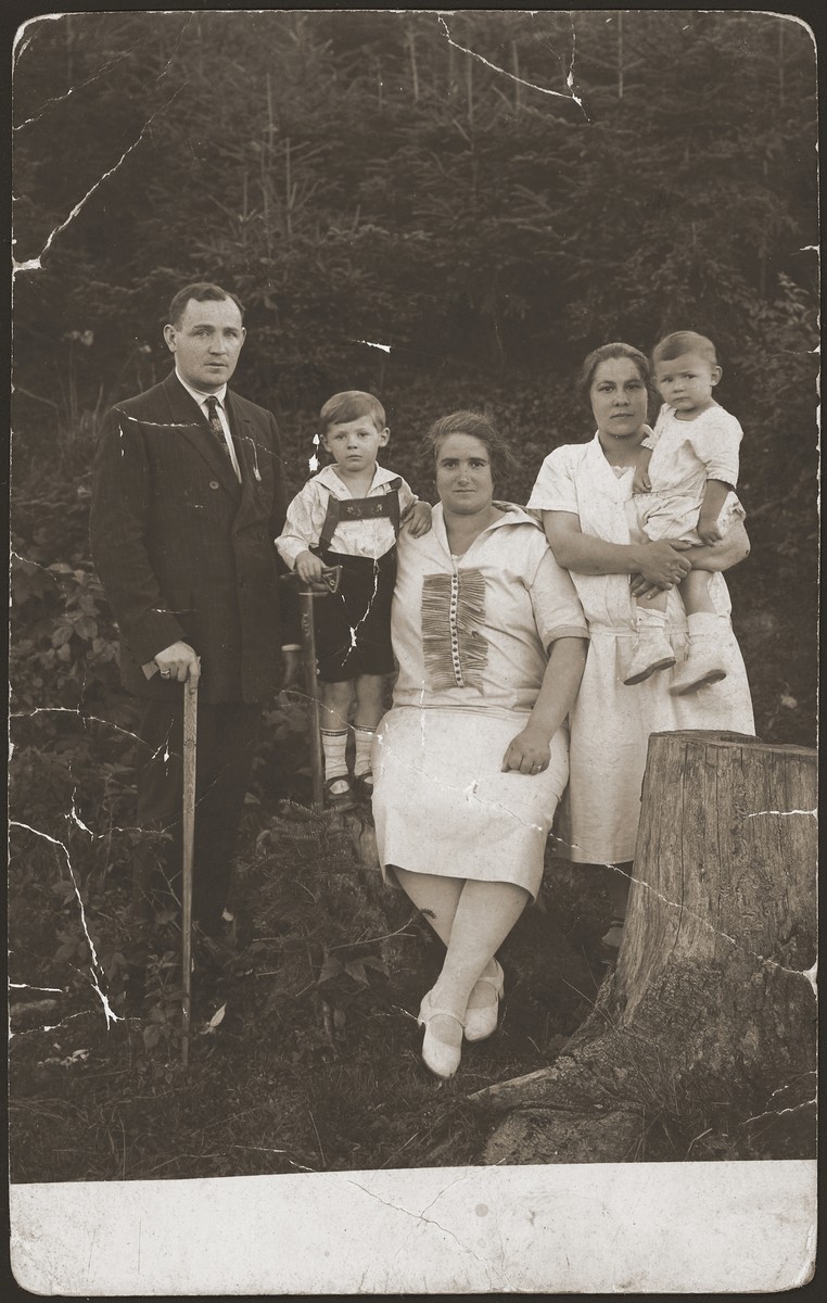 A Jewish family on a trip to Rabka, Poland poses outside during an excursion.  

Pictured from left to right are: Henry Seitler (Roman's father), Iziek Seitler (Roman's brother), Lea Seitler (Roman's mother), and the maid holding Roman.  Roman was the sole survivor of his family.
