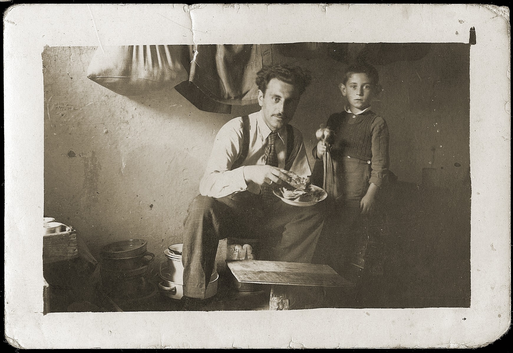 Mosa Mandil, a Jewish refugee from Serbia, poses with his son Gavra in the prison cell in which they are living in Italian-occupied Pristina.