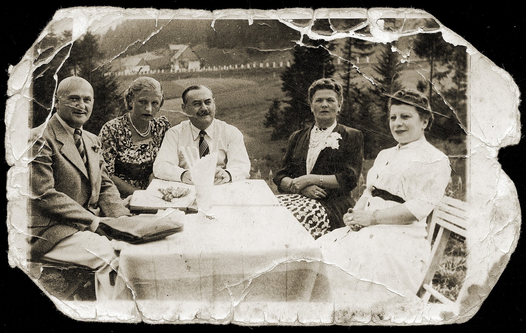 A group of friends sit outside around a table.

Pictured from left to right are: ? Pinkus, unknown, Simon Furstenberg, Helena (Goldminc) Furstenberg and Mania Pinkus.