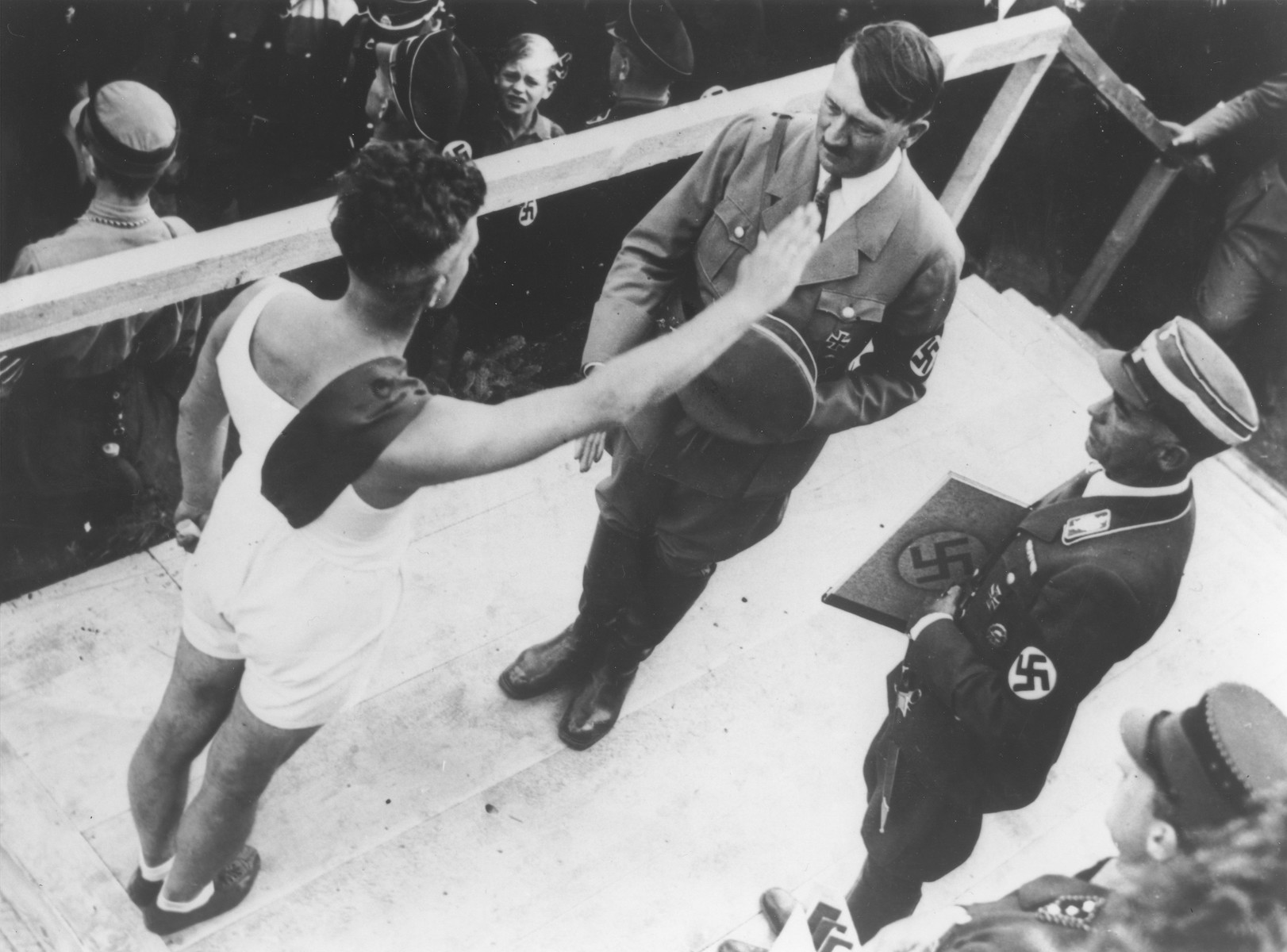 An athlete salutes Hitler at a ceremony to demonstrate loyaty to the Saar district at the Ehrenbreitstein fortress in Koblenz.   

Reich sports leader Hans von Tschammer und Osten (right) is about to present the athlete's message of loyalty to Hitler.