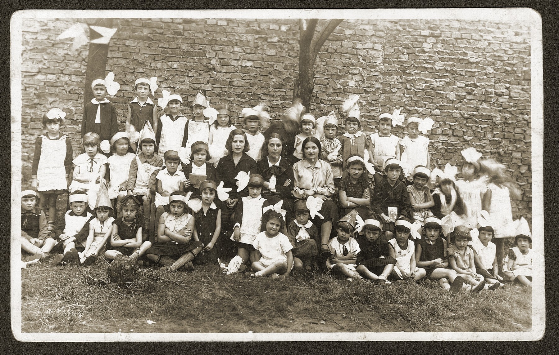 Group portrait of Jewish children and their teachers in a Bedzin kindergarten.  

Among those pictured is Fela Fiszel (front row, second from the right).
