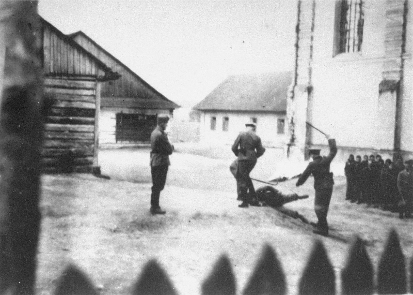 Camp guards beat a prisoner at the Cieszanow labor camp.