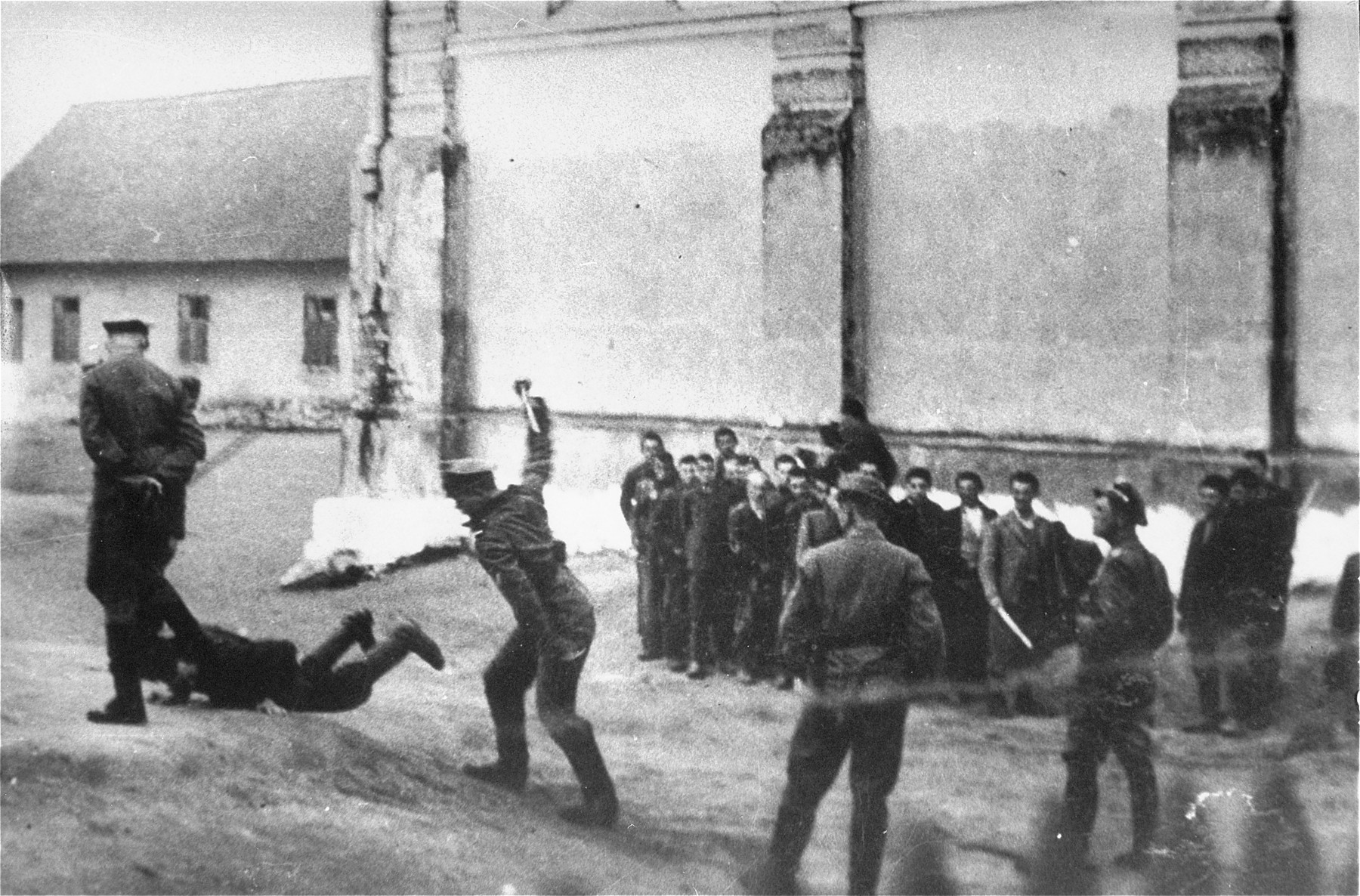 Camp guards beat a prisoner at the Cieszanow labor camp.