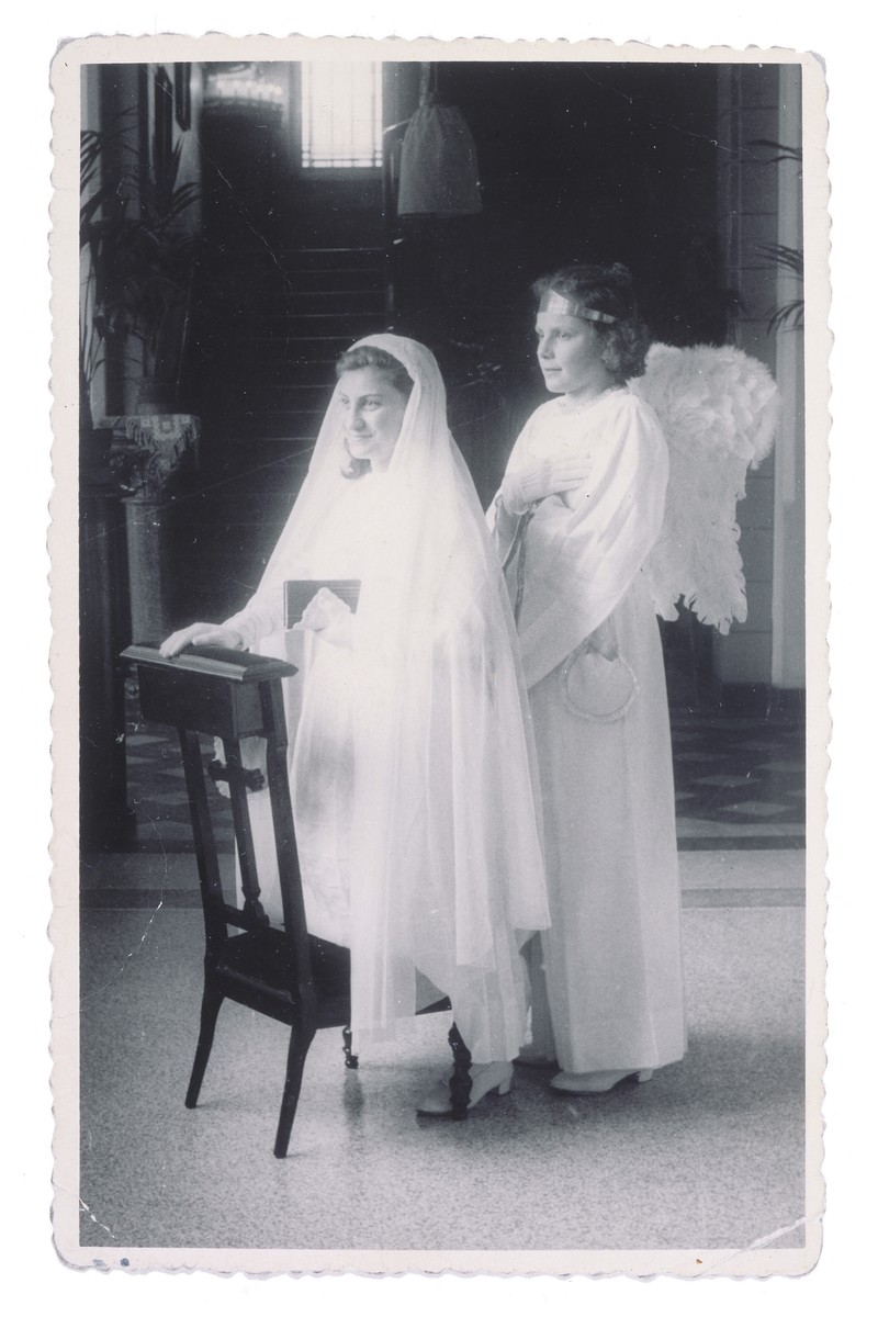 Portrait of a Jewish child in hiding on the day of her First Communion at the Soeurs de Sainte Marie convent school in Wezembeek-Oppem near Brussels.  

Pictured on the left is the donor, Sara Lamhaut, living under the assumed name of Jeannine van Meerhaegen.