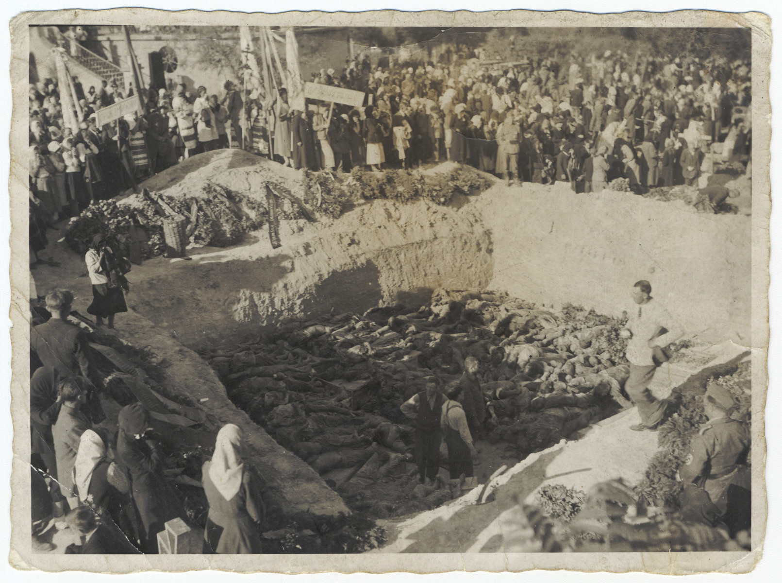 Civilians gather by a mass grave [probably during the invasion of the Soviet Union.]