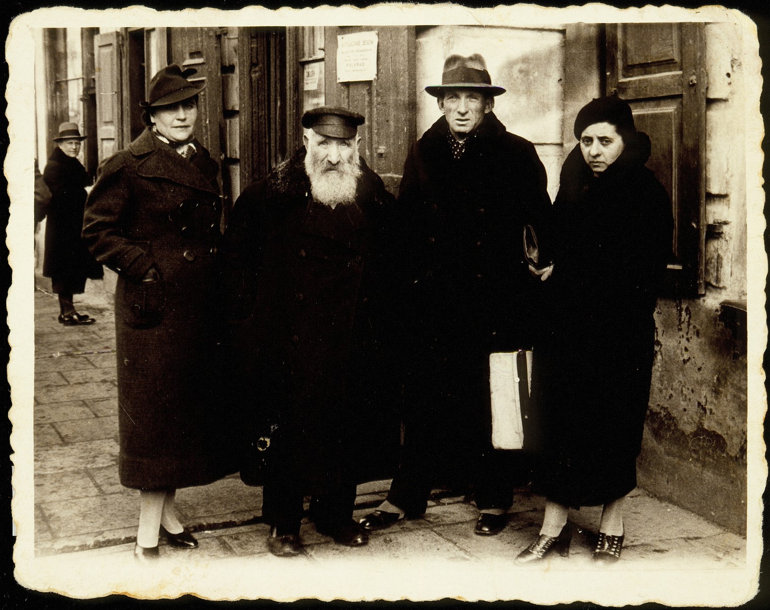 Members of the Kaganov family pose on a sidewalk in Grodno.  

From right to left Judith (Yonah) Szyszenski Kaganov, her husband Szymen Kaganov, Reb Reuven Kaganov and Ida Kanichowski Kaganov.  Reb Reuven Kaganov died a natural death.  Ida Kaganov was murdered by Poles and her two children.  Szymen Kaganov and his wife Judith (Yonah), and son Yaakov immigrated to Palestine.