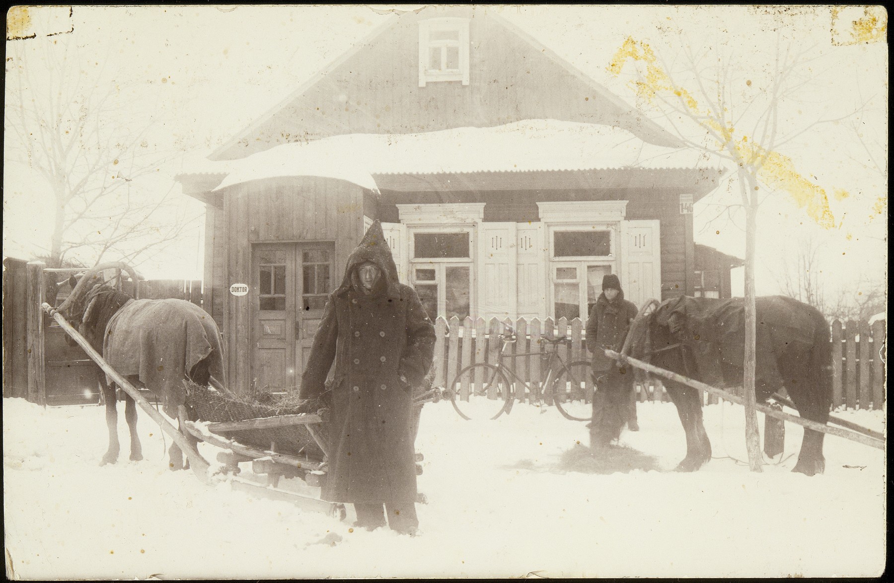 Two men stand by their horses and carts during a snow storm in Eisiskes.