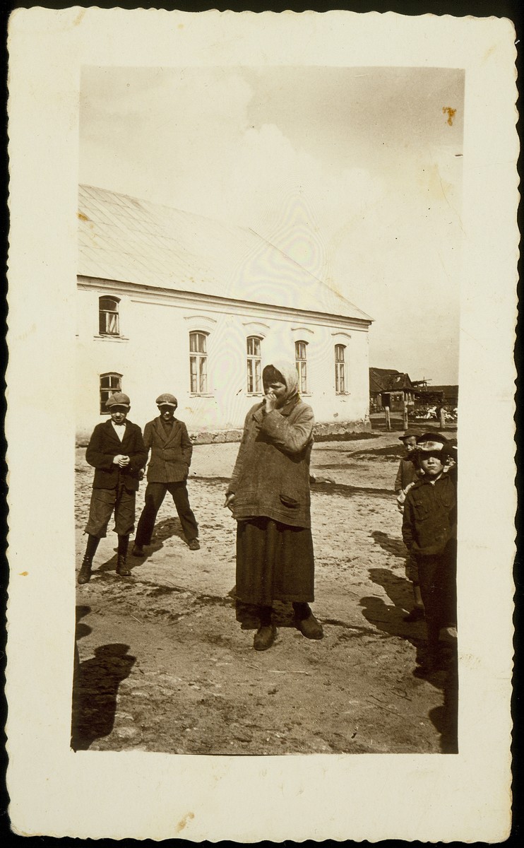 Liebke Kaminetski, a mentally ill person who came to Eisiskes during World War I, stands outside the New Beth Midrash.  

Liebke was murdered in the September 1941 massacre.