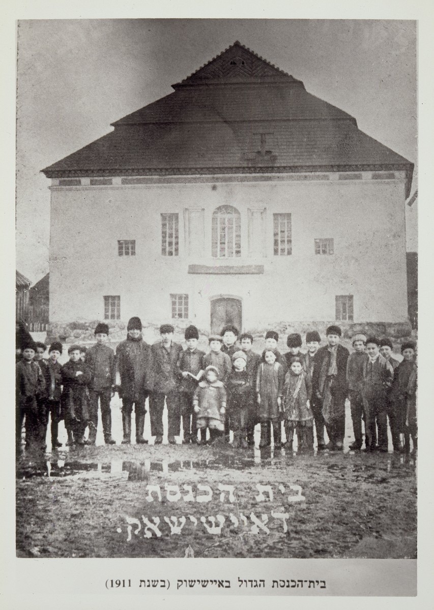 Children stand outside the main synagogue in Eisiskes.  

Those pictured include siblings from the Schneider, Sonenson, Wilenski, Kabacznik, and Resnik families and Shlomo Farber from Olkenik.