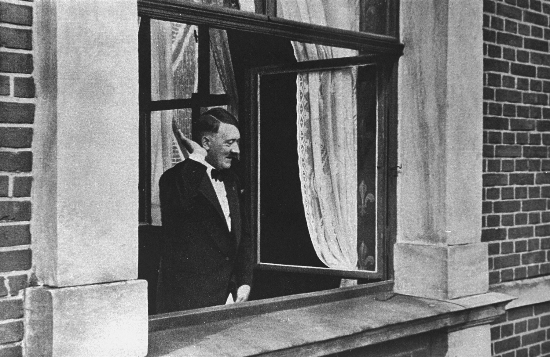 Adolf Hitler salutes a crowd from the windows of the Chancellory.

This photograph, perhaps a reenactment of his assumption of power on January 30, 1933, was reprinted as a propaganda postcard.