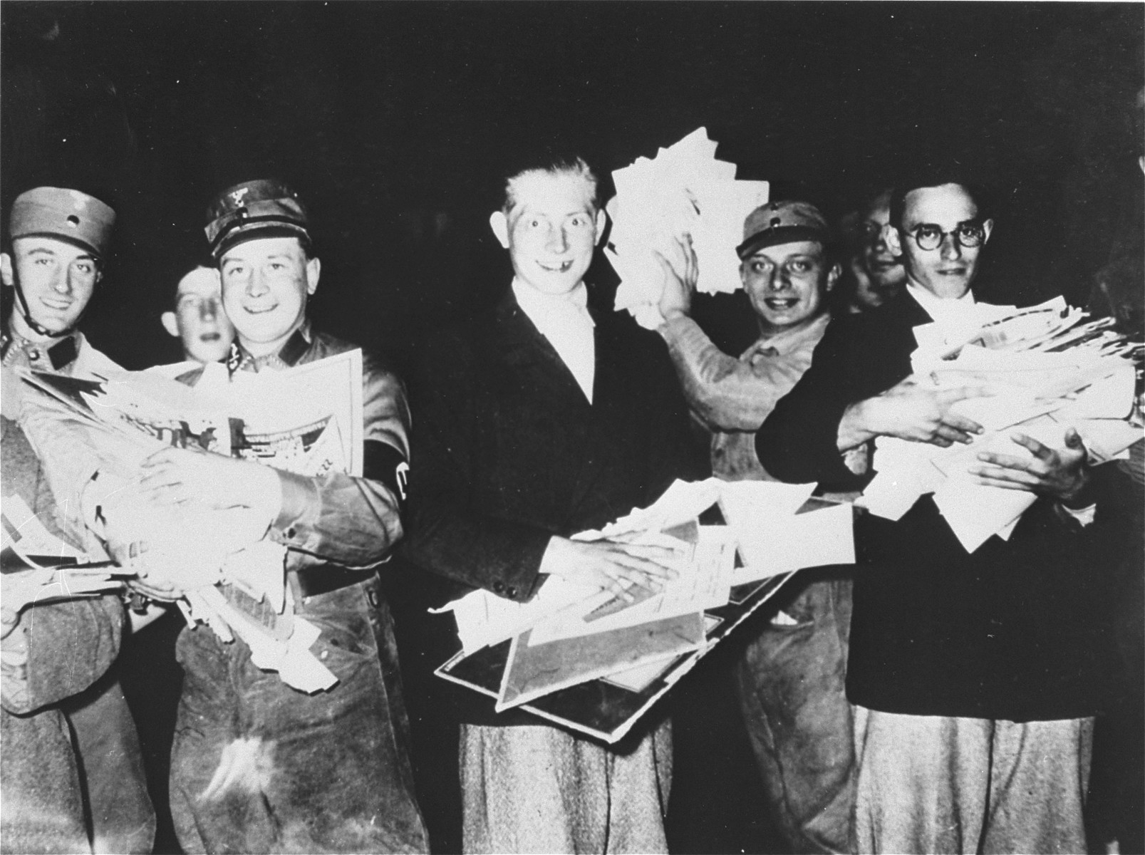 Students and SA members carry piles of "un-German" literature to throw into the bonfire on the Berlin Opernplatz.