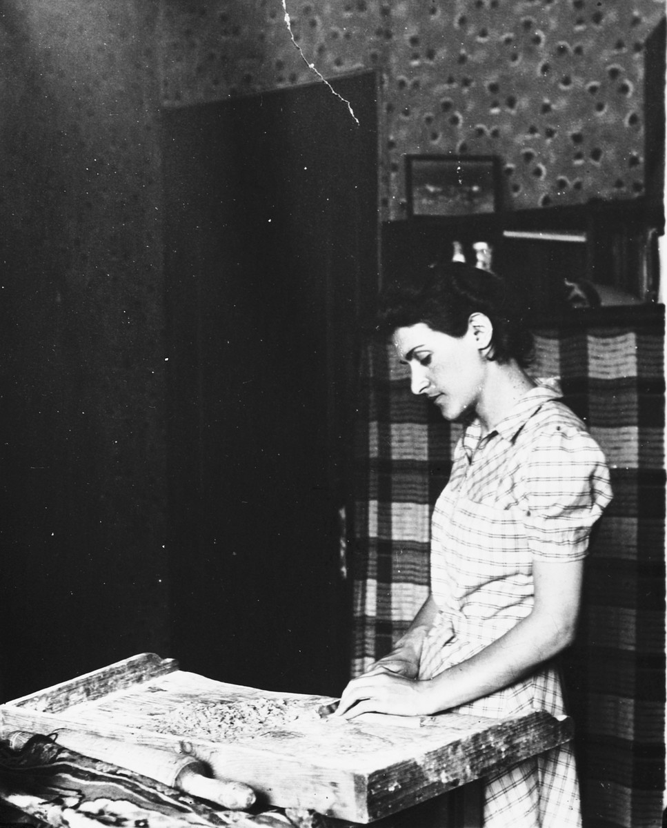 A young Jewish woman prepares homemade noodles in the kitchen of her apartment in Antwerp.

Pictured is Leah Ciechanow.