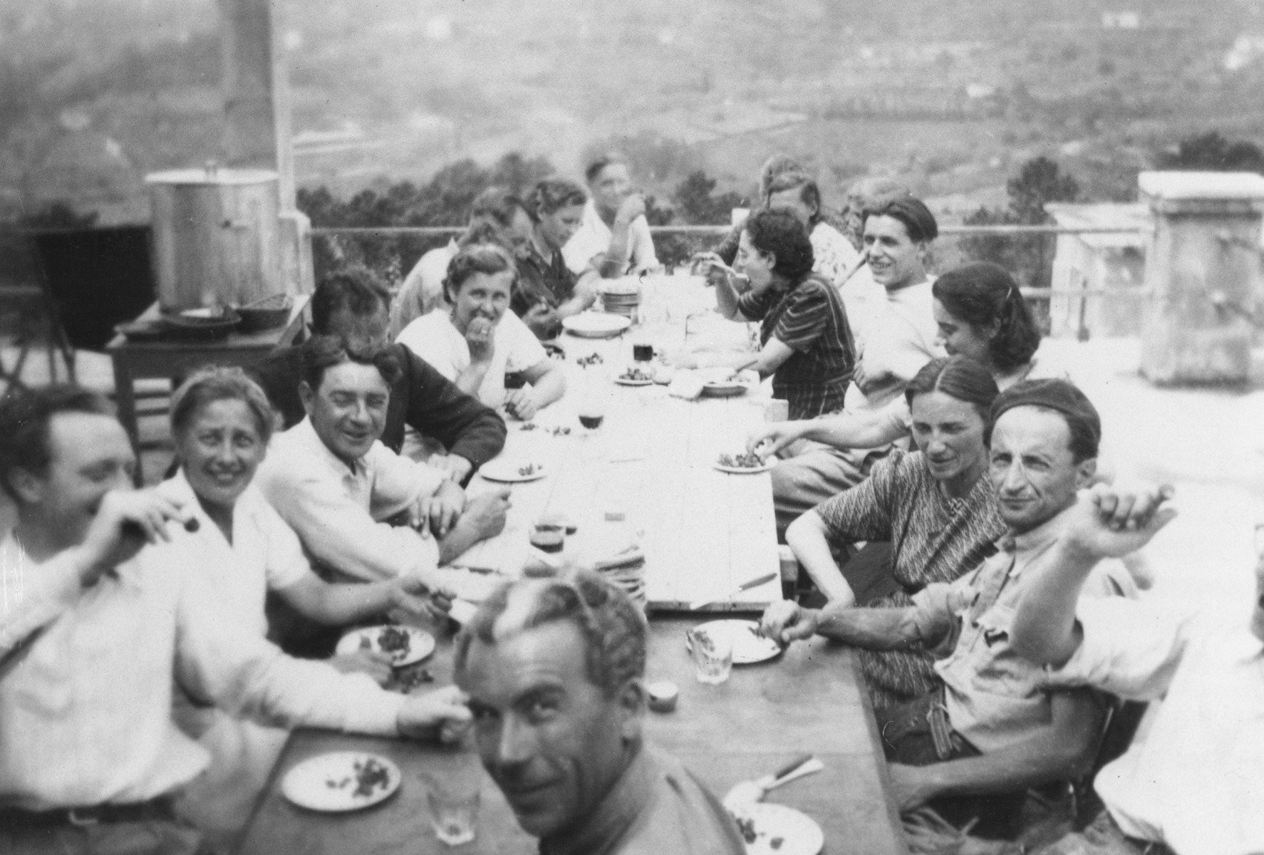 The staff of the MACE (Maison d'Accueil Chretienne pour Enfants) children's home at Vence eats a meal outside on the home's terrace.

Joseph Fisera is pictured in the front facing the camera.