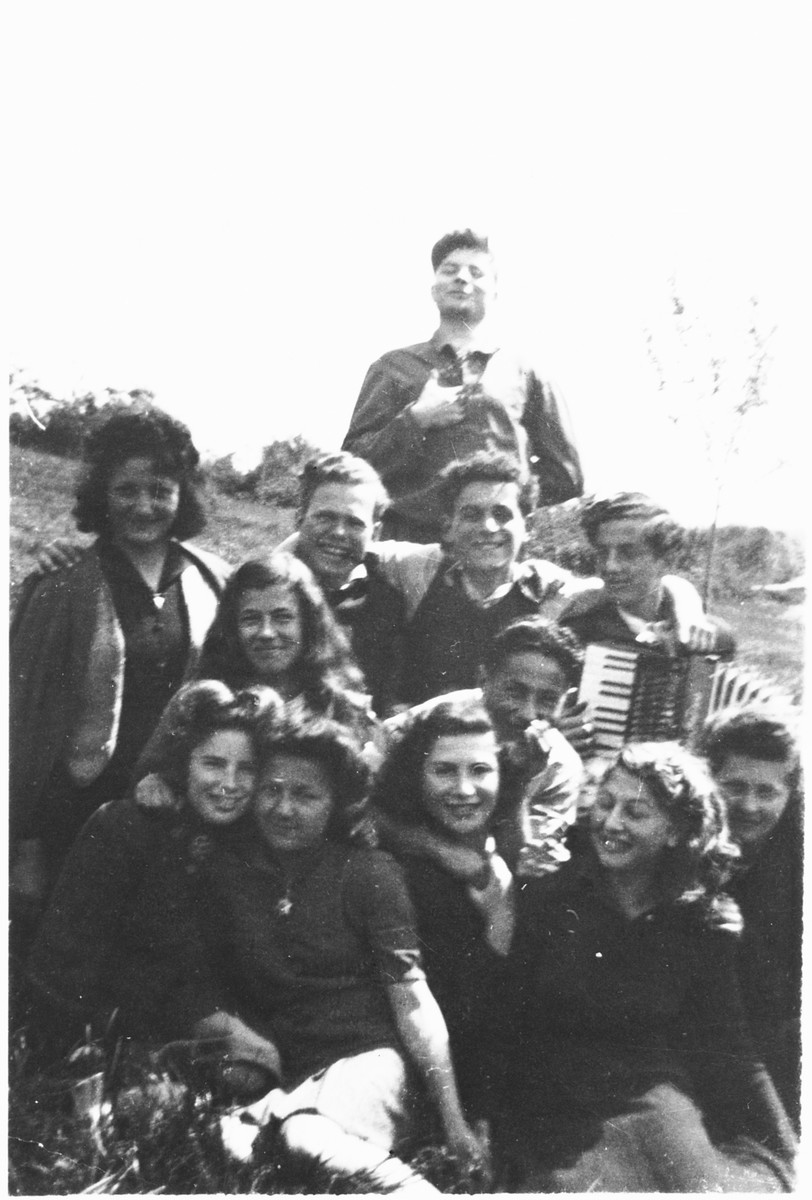Group portrait of Jewish DP youth outside the Poulouzat children's home. One of the teenagers plays an accordion.

Among those pictured are Manfred Rosenberg (standing at the back) and Herbert Karliner (third row, third from the right.