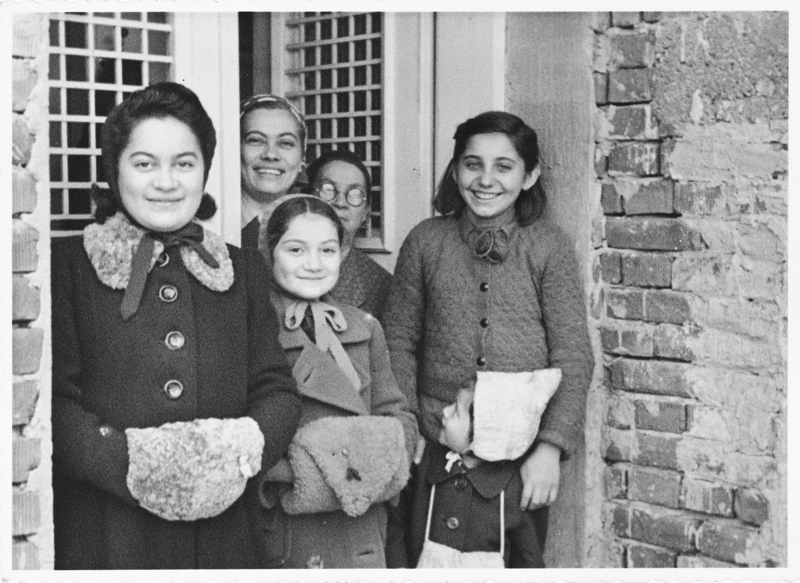 A Jewish family poses with their Croatian neighbors and friends.

Pictured in the ffront from left to right are: Zdenka and Vera Apler and their young cousin Dorica (Theodora) Basch.  Standing behind them are Blanka Apler (the mother of Vera and Zdenka), Maria Runjak and Stefica Grabaric.