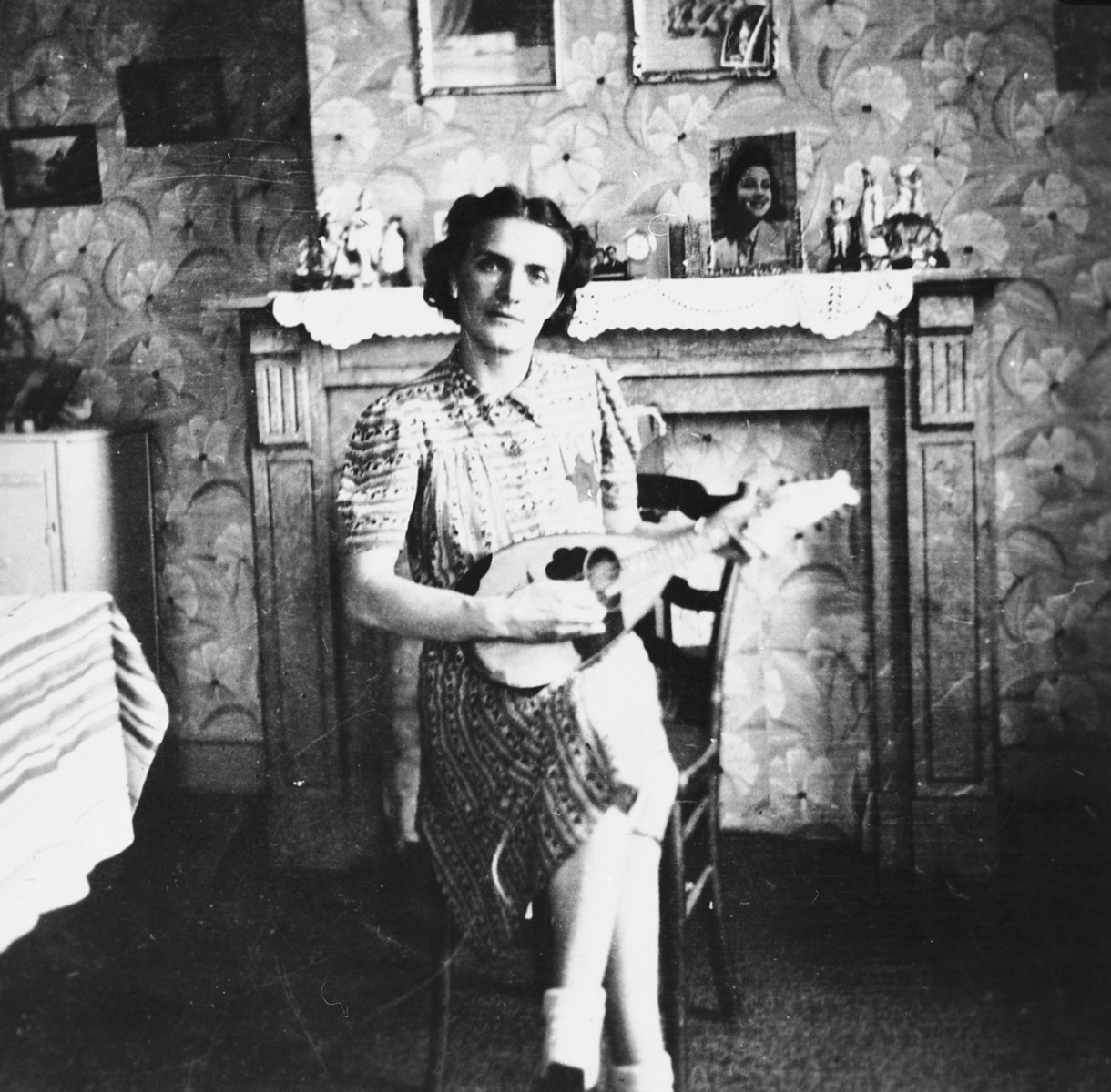 A Jewish woman living in hiding as a Christian, plays the mandolin in her apartment in Brussels.

Pictured is Leah Ciechanow.  She was subsequently deported to her death in Auschwitz.