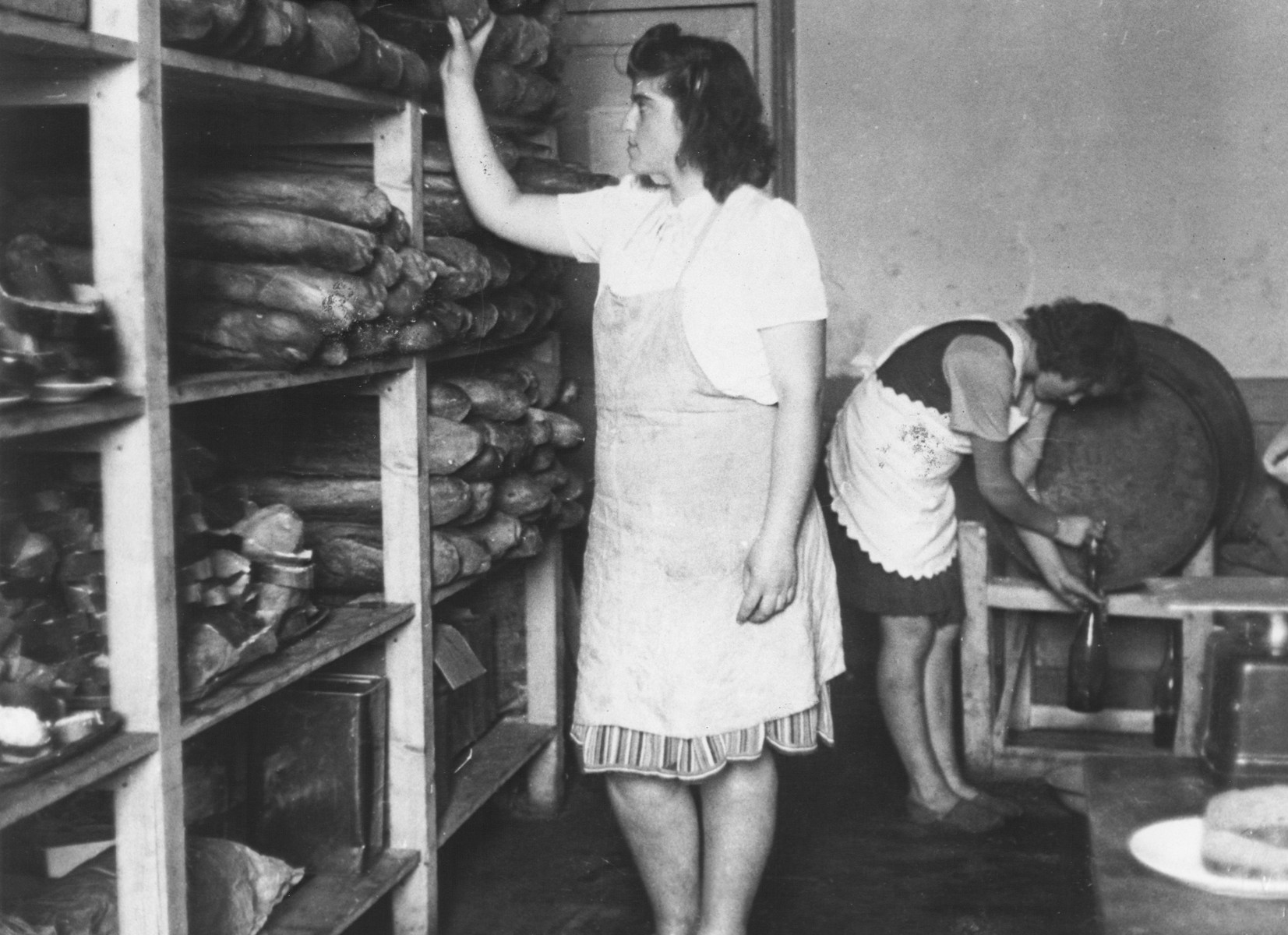 Ethel Zloczower, a Romanian Jewish teacher, stands by a bread pantry in the children's home in Vence.