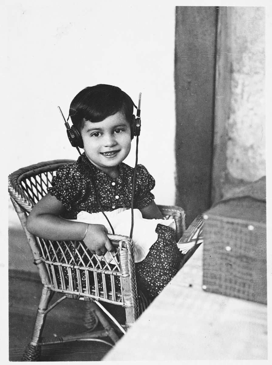 A young Jewish girl listens to a radio with head phones.

Pictured is Zdenka Apler.