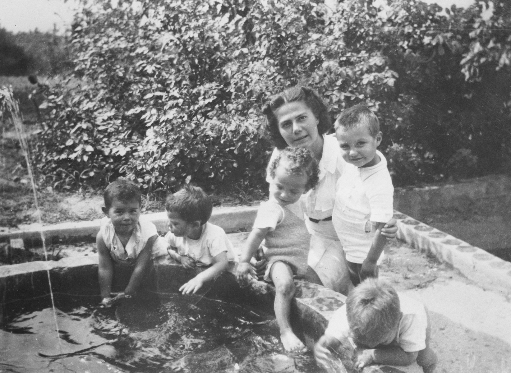Lydia Turznikova helps a group of toddlers playing in a fountain, in the MACE children's home in Vence.