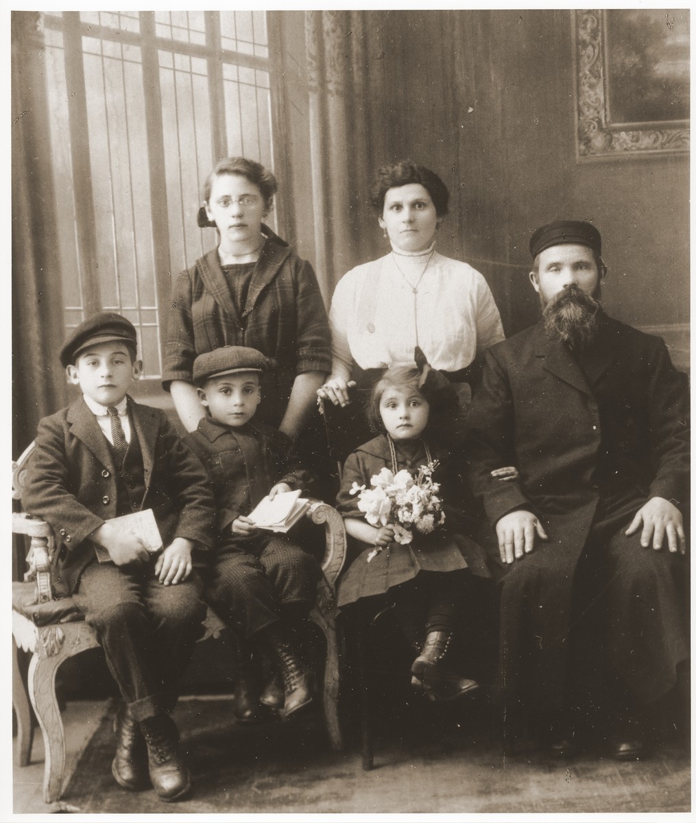 Formal portrait of the Dresner family in Lazy, Poland.

Standing from left to right are Fajgale, Dawid-Zelig and Chana Dresner.  Seated are Mosze-Szmuel and Cirele Dresner.