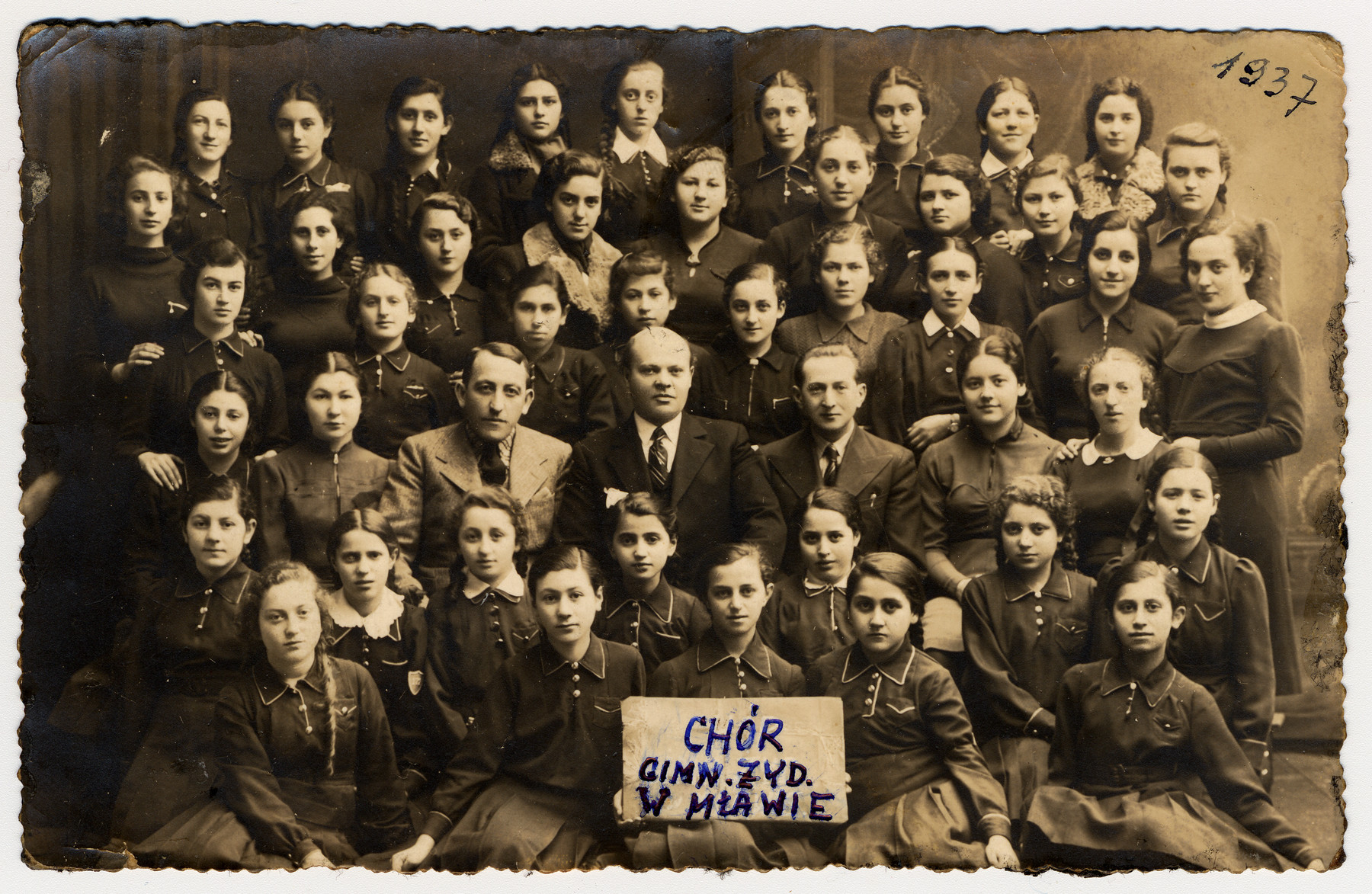 Group portrait of the choir of the Jewish gymansium in Mlawa.

Seated in the second row are the conductor Issachar Fater, Rosebery d'Arguto (real name Martin Rosenberg) and Dr. L. Rozman.