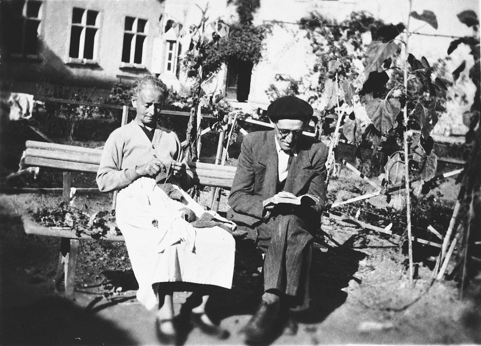 Mr. and Mrs. Nadal, Spanish refugees and staff of Chateau de la Hille, relax outside by knitting and reading.