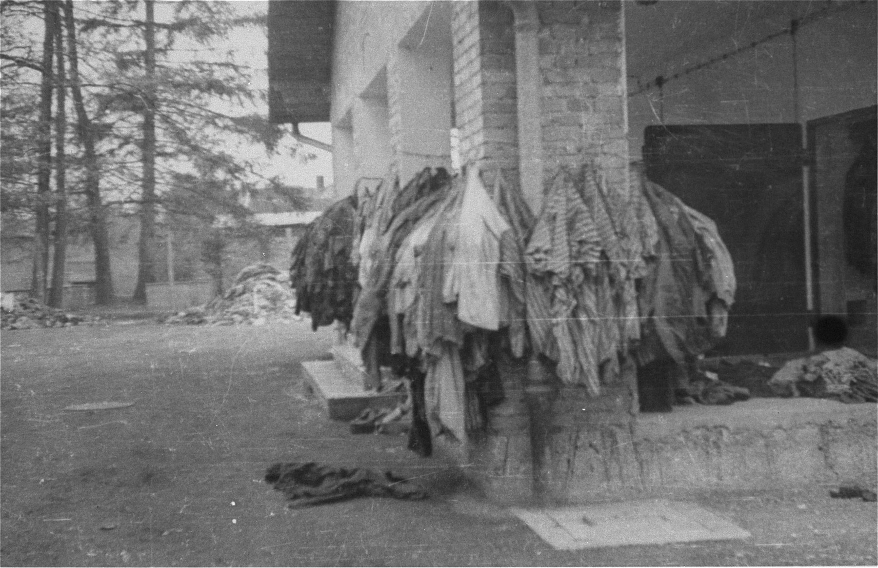 Prisoners' uniforms hung up outside a camp building.