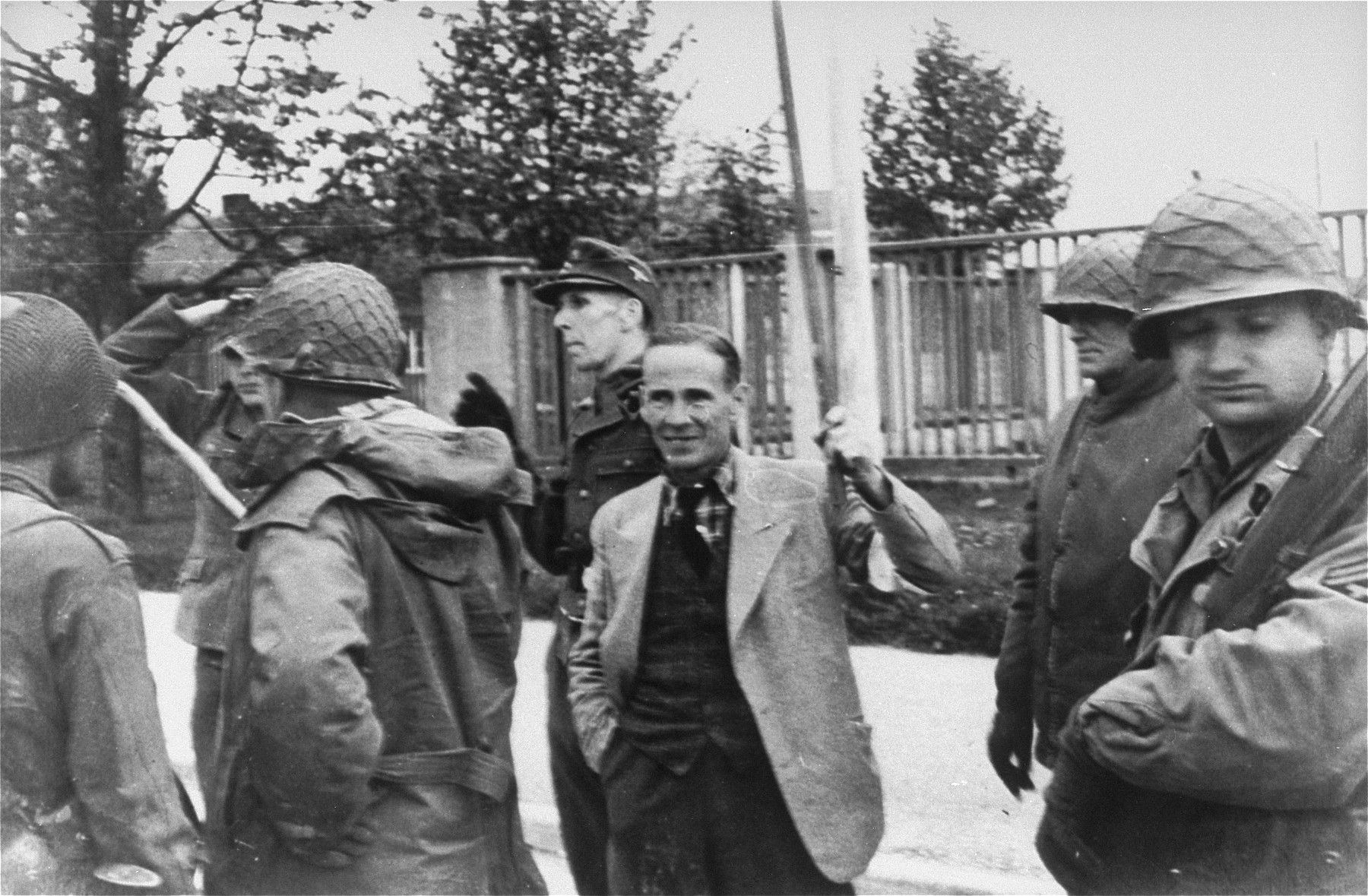 Brigadier General Henning Linden, assistant commanding general, 42nd Rainbow Infantry division, with his back to the camera, accepting the surrender of SS Lt. Wickert.  The man in the middle is ICRC (International Committee of the Red Cross) representative Dr. Vincent  Maurer, acting as a translator for the surrendering Germans. [oversized print]