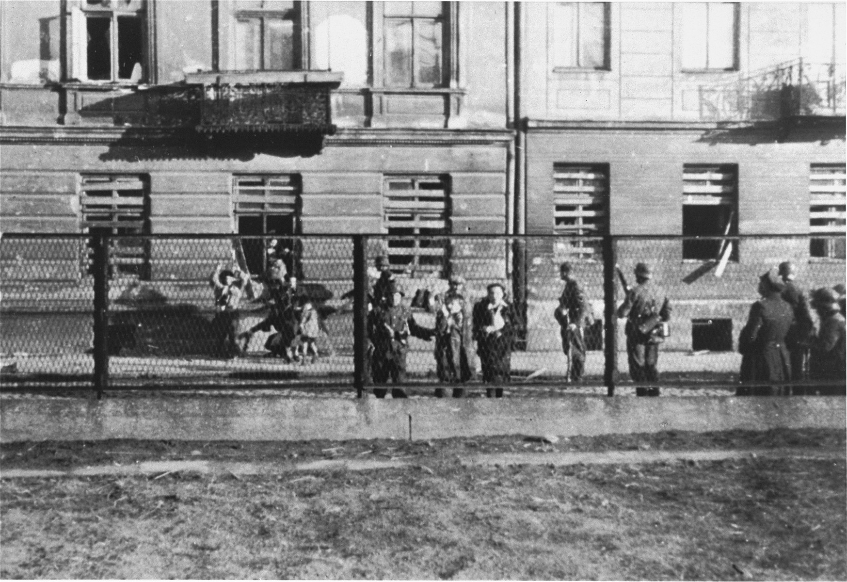 SS troops force Jewish families to evacuate an apartment building during the suppression of the Warsaw ghetto uprising.