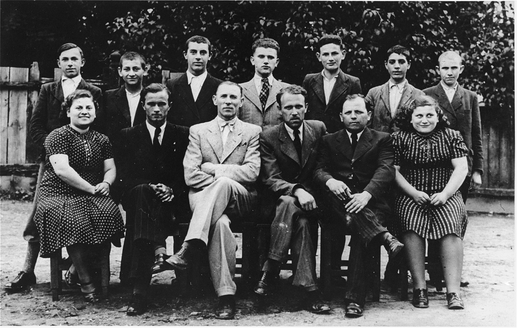 Group portrait of students who are training to be tailors at a vocational school in Tacovo.

Pictured in the front row, from left to right are: Malvina Ickovic; Jonko Jeno (the Hungarian language teacher); Raives (the director of the school); unknown; Mendel Rezmovics (a teacher); and Sheindy Ickovic.  In the back row, from left to right are: Horbas; Tobias; Stal; Ludvic Ickovic; Lajbl Fixler; Cali Kaufman and Moshe Joel Smajovics.
