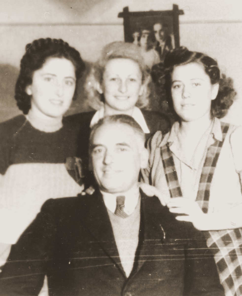 Group portrait of four Jews in an apartment in the Cernauti ghetto.

Pictured standing from left to right are Erika and Beatrice Neuman and an unidentified woman; seated is Dr. Heller.