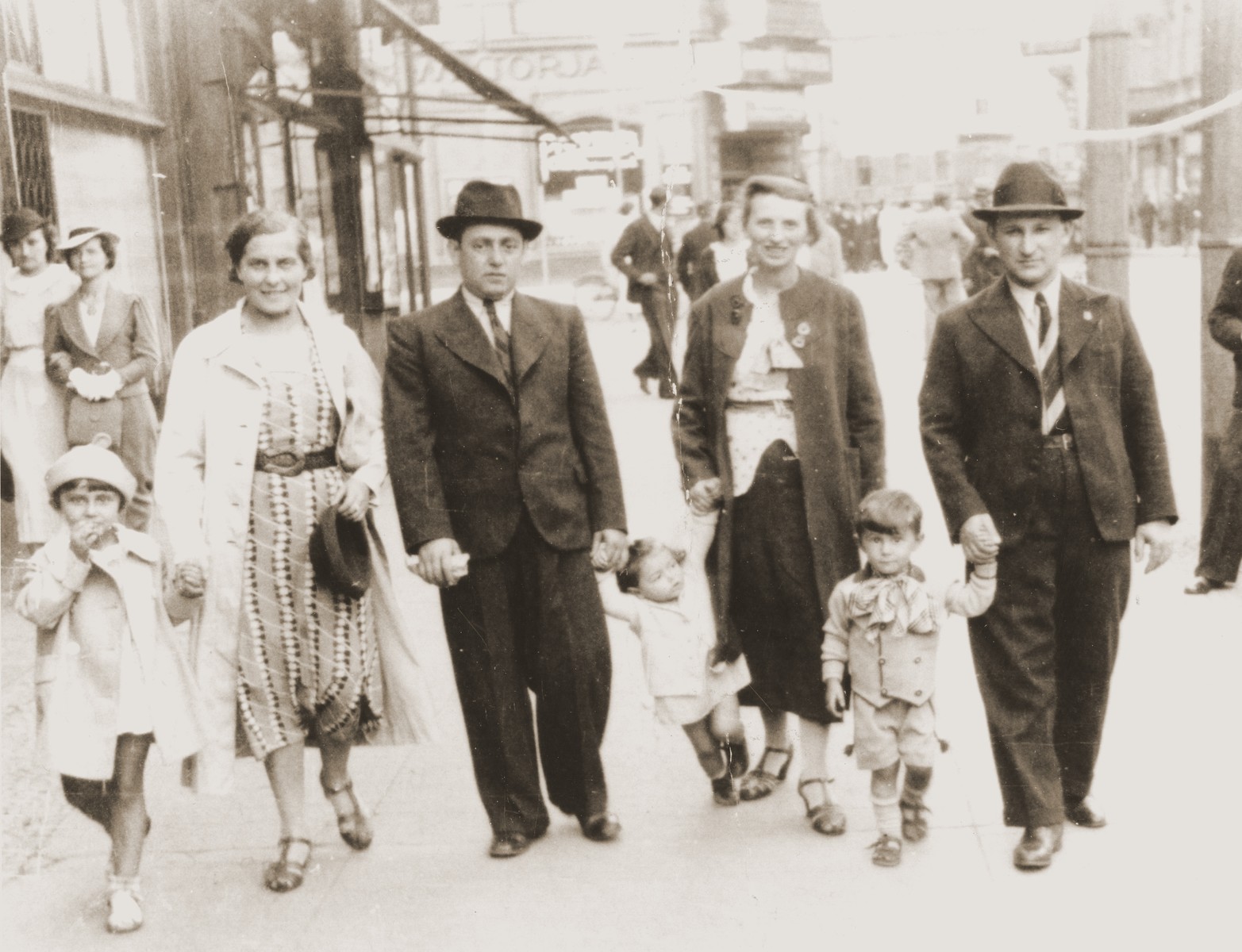 The Goldblum family taking a Sunday stroll on the streets of Katowice.  

Salusia and Tola are holding hands on the left, while Izak and Wolf are on the right.