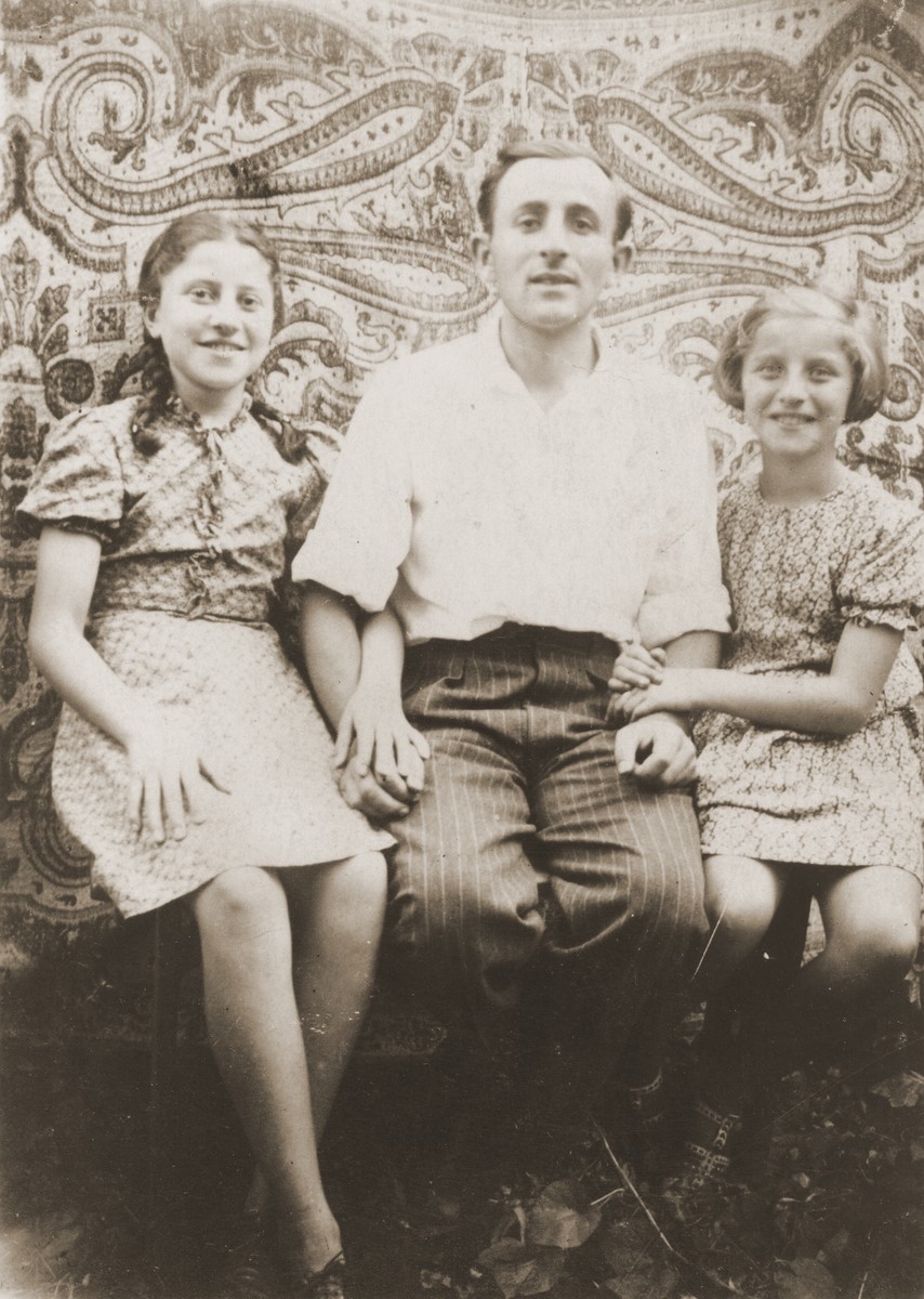 Hania and Rachela Goldman pose with their cousin, Mordka Kohn, during his visit to their home in Zabno, Poland.