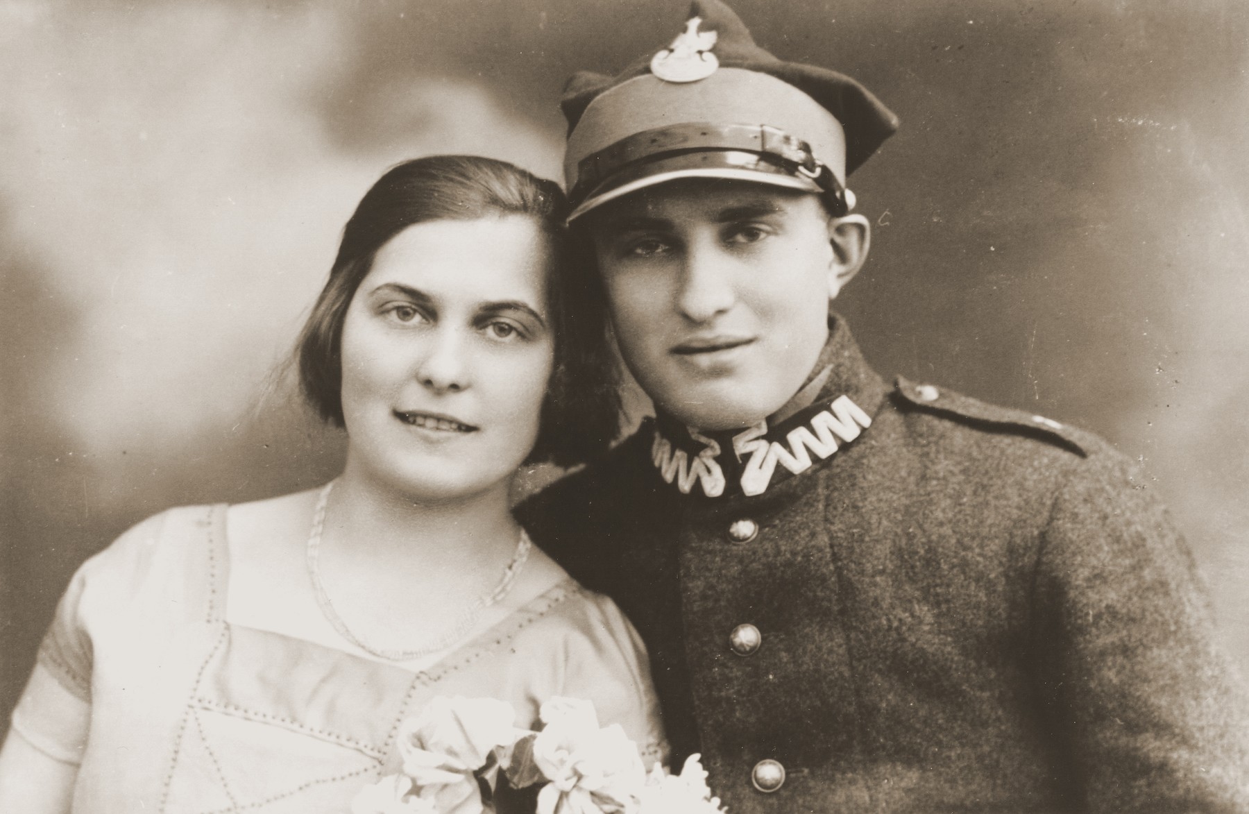Studio portrait of two Jewish siblings in Zarki.

Pictured are Tola and Moszek Broda.  Moszek is in the uniform of the Polish army.