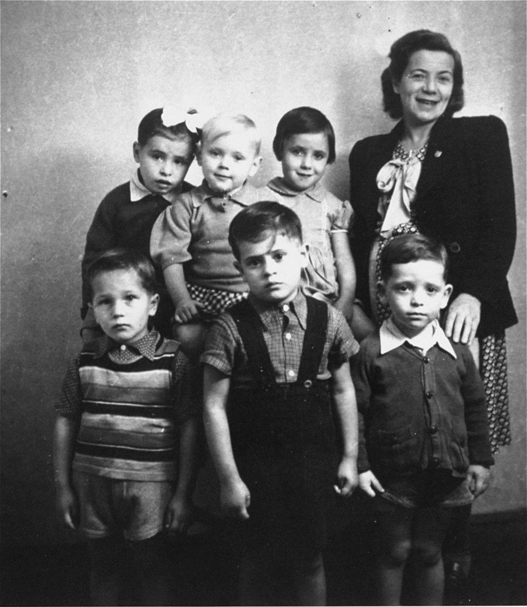 Bina Halperin poses with a group of six Jewish orphans at a children's home in Austria run by the American Joint Distribution Committee. These children were part of a larger group of twenty to thirty orphans who were removed by Bina Halperin from a convent in Poland were they had been hidden during the war.