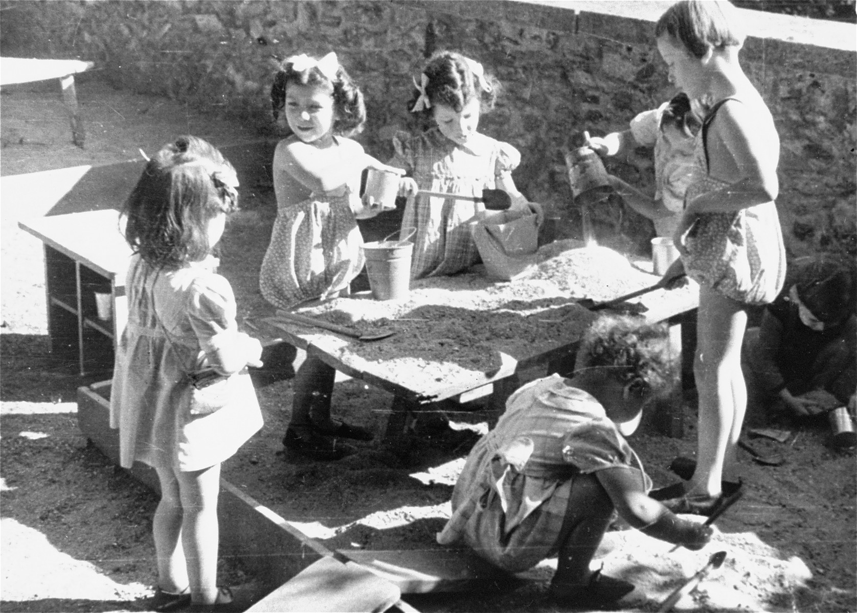 Young Jewish children play in a sandbox at the Le Petit Monde children's home near Paris.