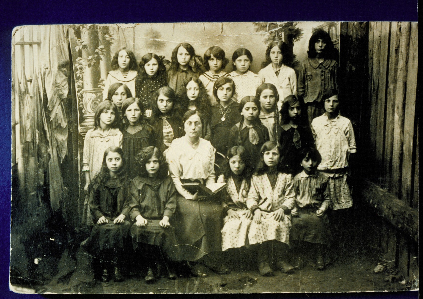Students at the Yaffskaya Shkola, a school for girls founded circa 1911. 

The school's official languages were Russian and German, with courses in Yiddish.  Sitting in the center is the founder, Mrs. Yaffe.  To her left is Zipporah Lubetski.    Zipporah and her sisters emigrated to Palestine and America, as did a few other girls in the photo.  Also pictured are two Kanichowsk sisters (possibly Kreinele and Gutke). The majority of the girls were murdered by the Germans during the September 1941 mass killing action in Eisiskes and other locations.