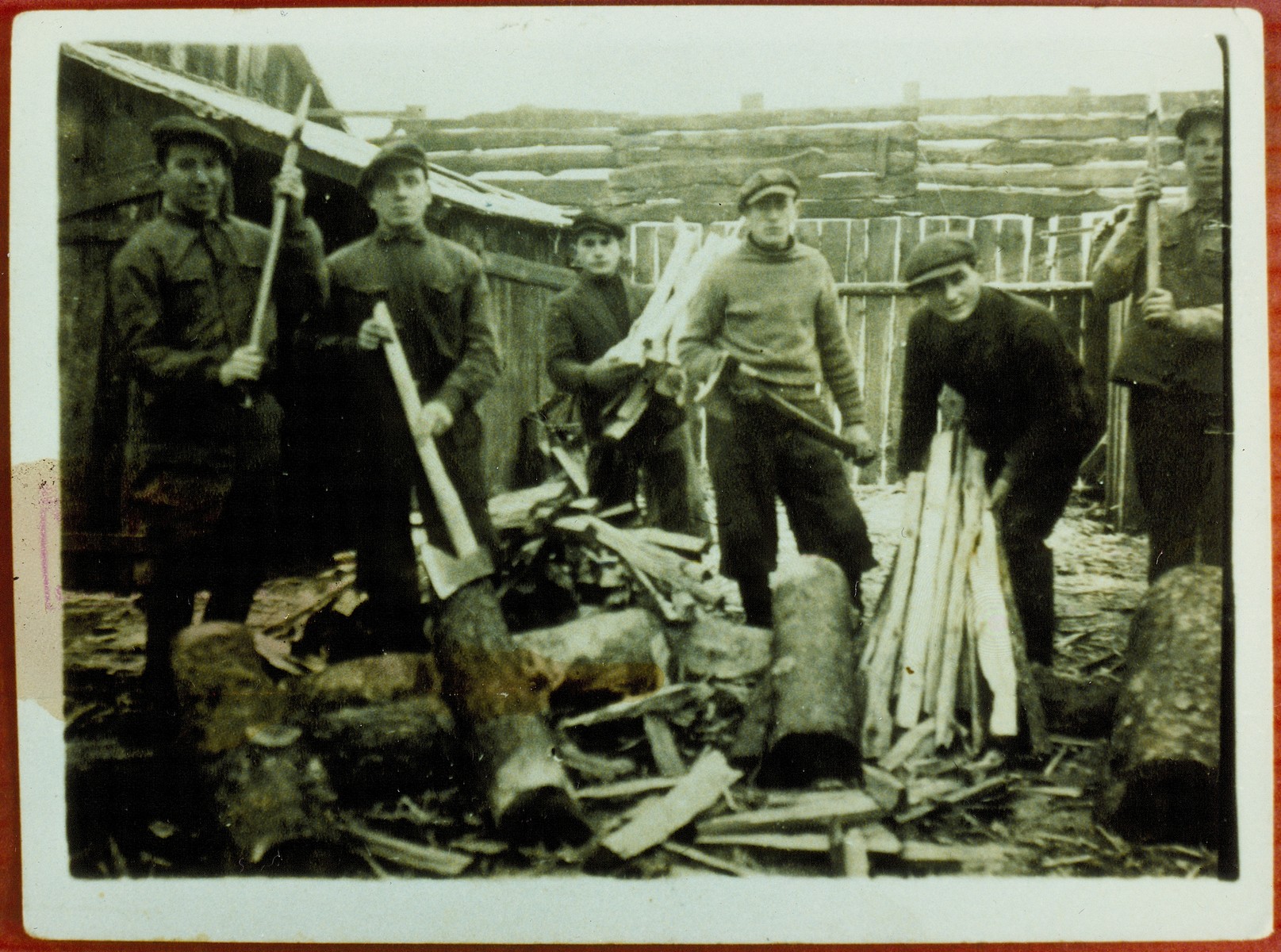 Members of a kibbutz hachshara from chop wood in a lumberyard.