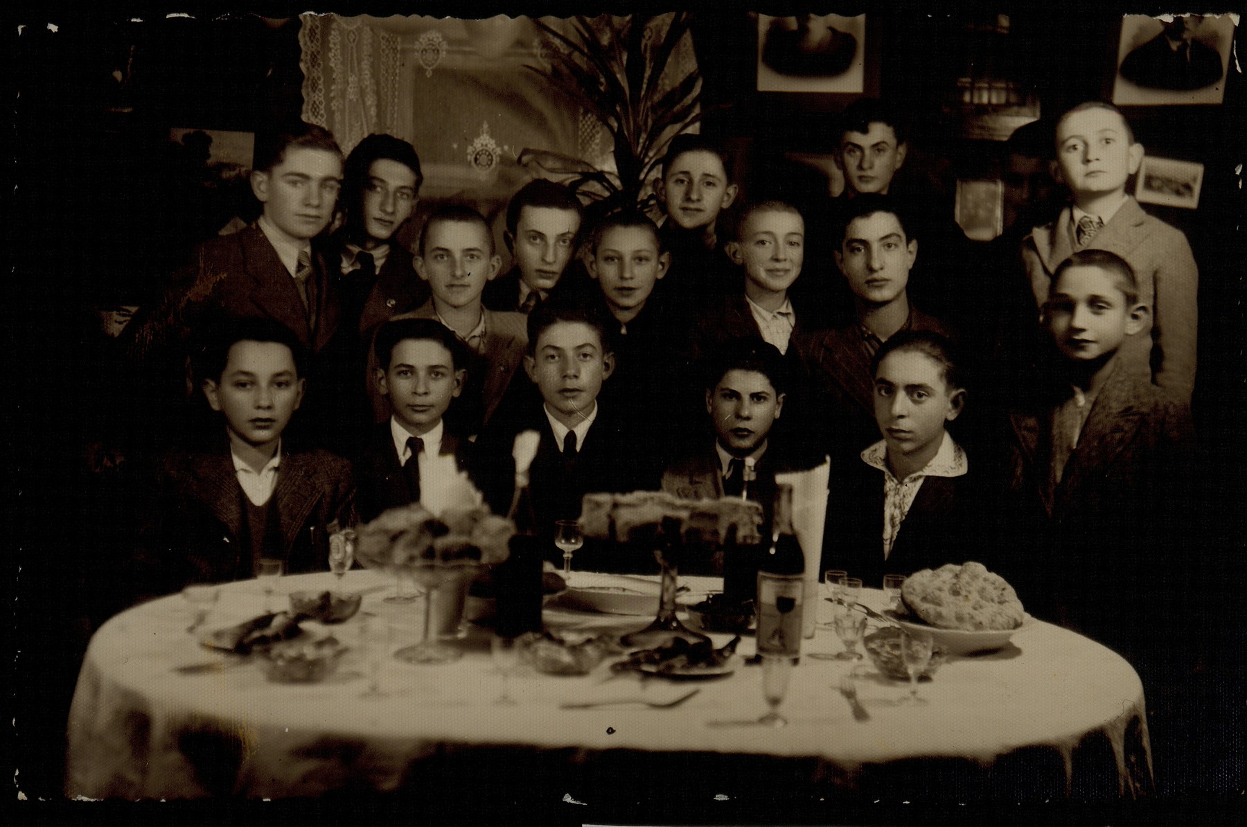 A farewell party for the Shlanski brothers in honor of their impending immigration to America. 

Sitting from left to right: unknown, Benjamin Shlanski, Fischl Shlanski, Tuvia Blacher, Moshe Ginunski. Standing at far right (in front) is Moshe Kremin (a cousin of tShlanskis).  Second row, right to left: Leon (Leiba) Shlanski, Zalman Zubizki., Bezalel Charney.  Names of other boys are unknown. 

The Shlanski siblings immigrated to America.  All the other boys in the photo were murdered by the Germans during the September 1941 mass killing action in Eisiskes.